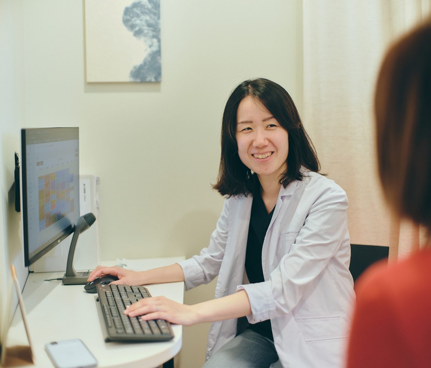 Dr. Ishibashi talking with a patient in the consultation room
