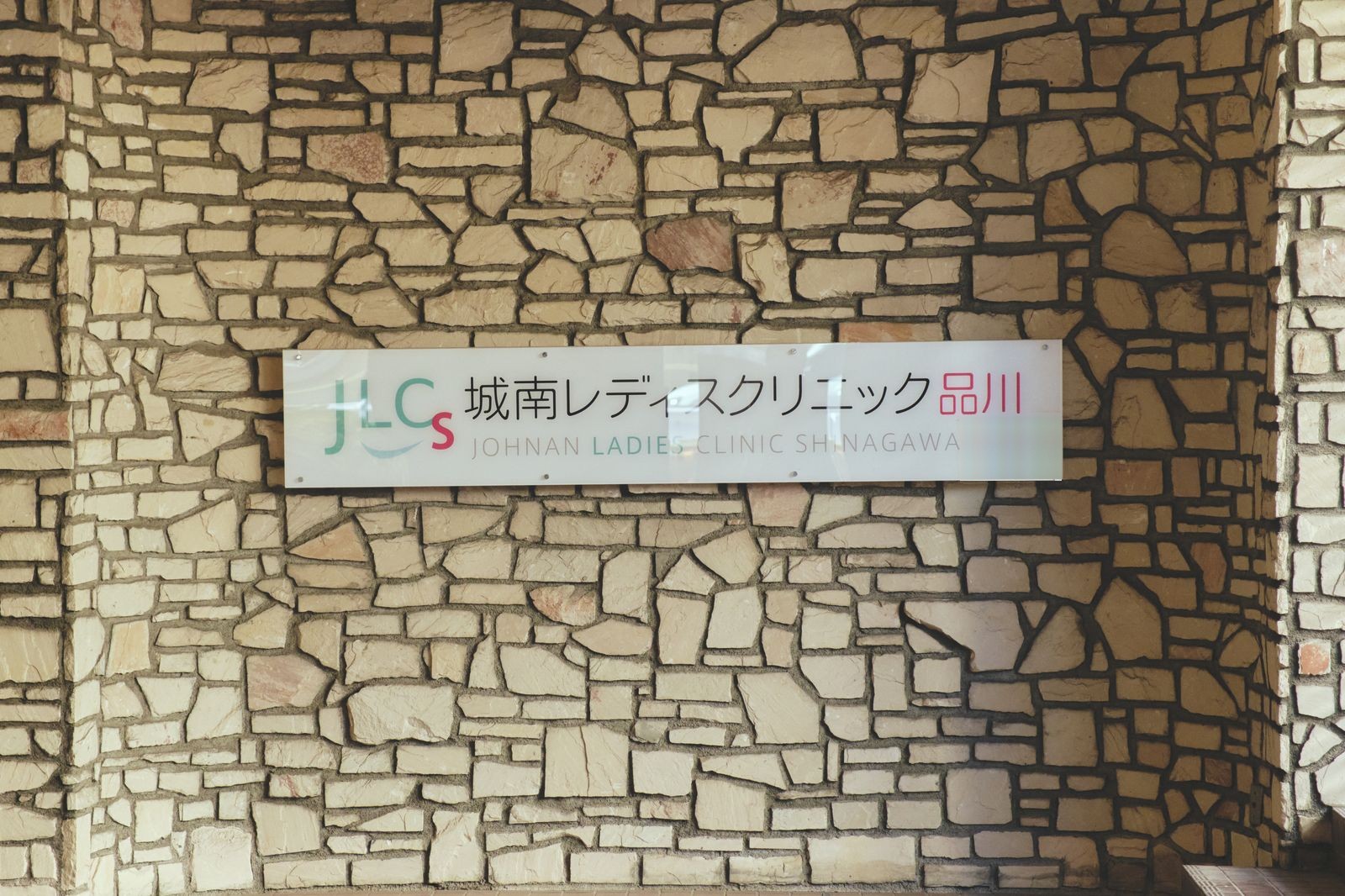 石壁に掲げた、クリニックの院名の看板
